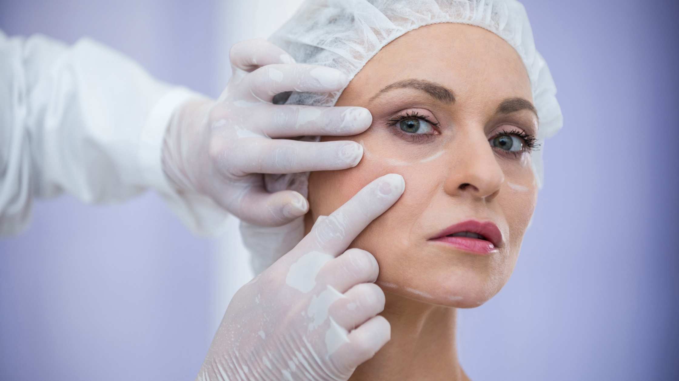 Plastic surgery surgeon in Thodupuzha examining facial skin before cosmetic treatment